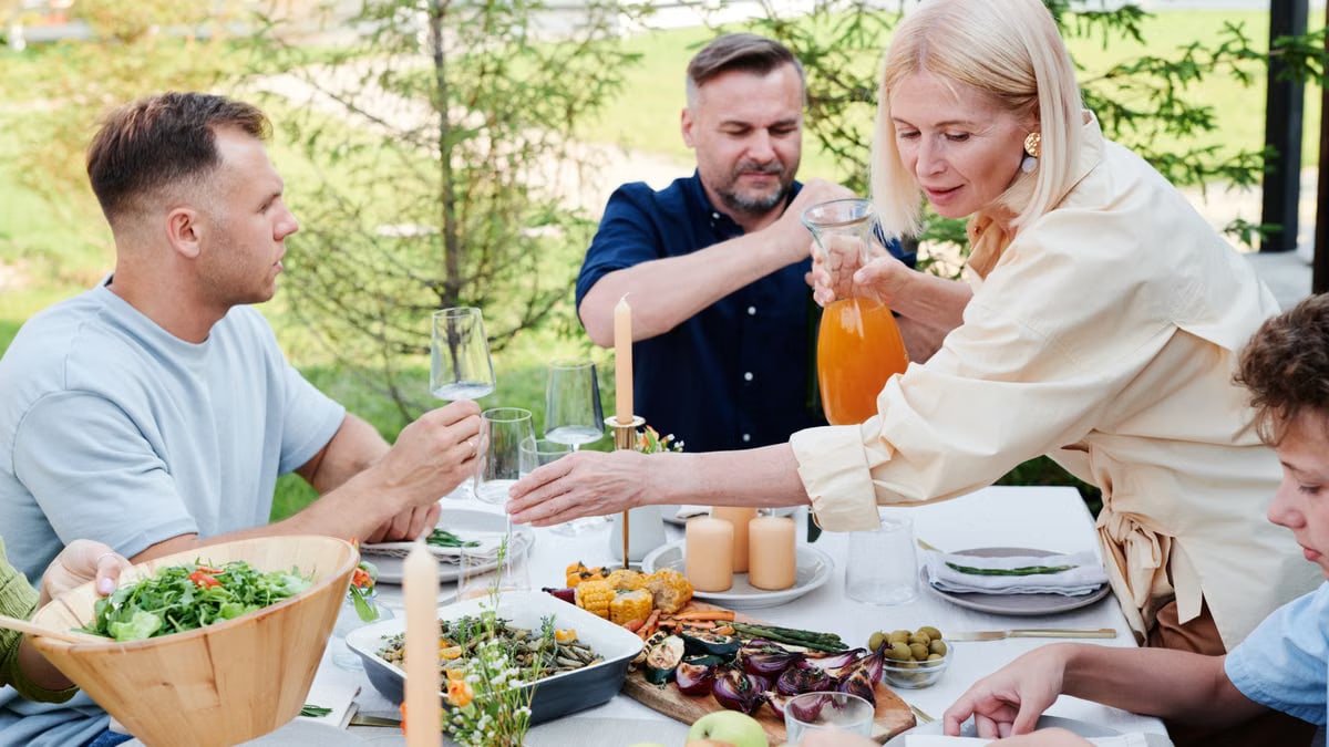 Family dining outdoors with salads and drinks, enjoying a vibrant summer lunch.